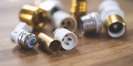 Different types of light bulb sockets on a wooden surface.