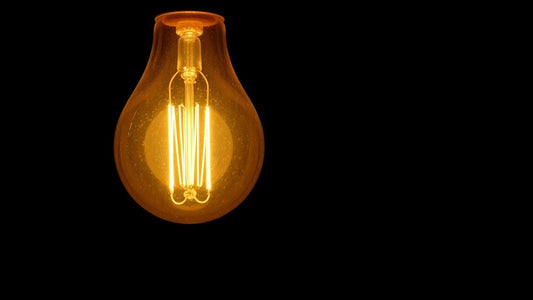 Glowing vintage light bulb with visible filament.