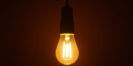 Bright light bulb glowing in a dark setting.